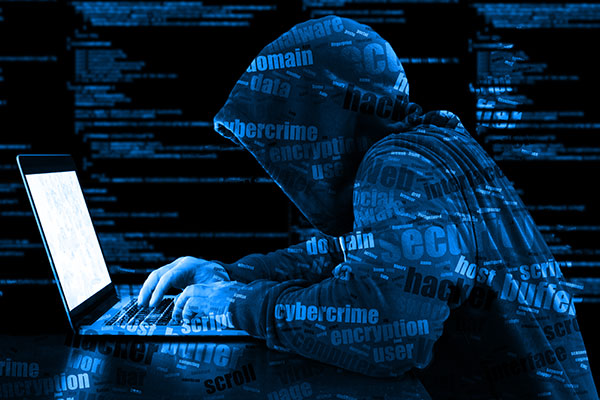 Student in hoodie working on laptop